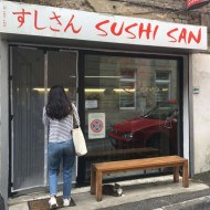 The Sushi San restaurant entrance, with a glass front