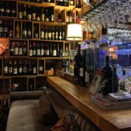 A sofa and a shelf filled with wine bottles inside Dekanter wine bar