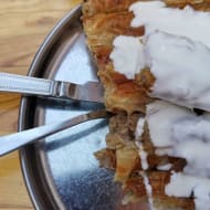 A plate of burek with yoghurt pured on top